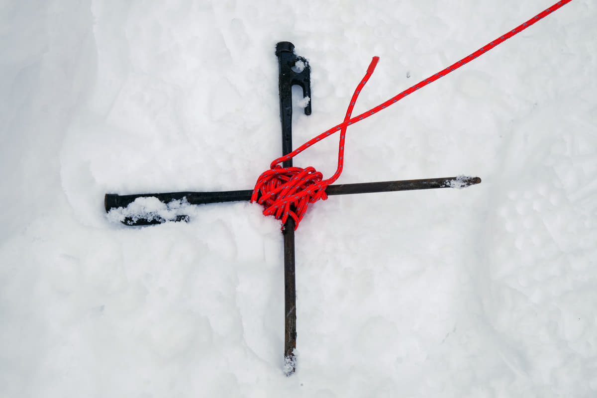 雪上での設営ではペグを十字に組んで雪に埋める
