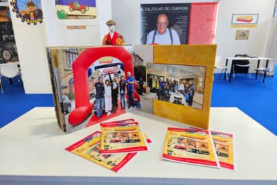 会場のカウンターには、今年のジーロ・ディ・シチリアにて「伊香保おもちゃと人形自動車博物館」の横田館長が優勝した際の写真も飾られていた