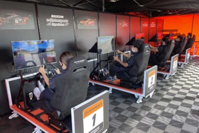 e-Motorsports（レースゲーム）は、リアルなハンドル・ドライビングシートを使用しながら、eスポーツ施設「REDEE」とオンラインで接続し、実況の付いたレースを誰でも楽しむことができる体験型イベント