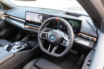 BMW現行5シリーズ。カーブド・ディスプレイの採用により、スイッチ類が少なくすっきりしたインテリア。走行モードなどで色が変化するインタラクション・バーが、インパネ中央からドア・トリムまで配される