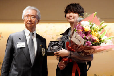 「スター・オブ・トゥモロー」受賞の野田樹潤選手に高橋晴邦さんよりクリスタルの盾が手渡された