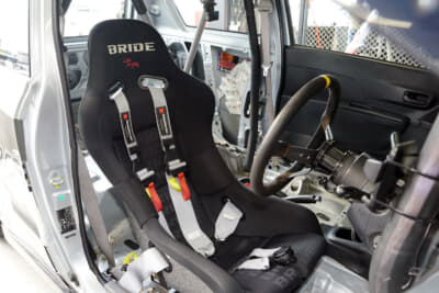バケットシートはブリッド。HPIの6点式シートベルトは安全性はモチロン、ボディカラーとのコーディネイトを考えて選んだという