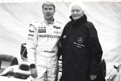 メルセデス・ベンツクラシックのジャンパーを着たマンフレッド・フォン・ブラウヒッチュは、1998年と1999年の2年連続F1ワールドチャンピオンになったミカ・ハッキネンとウンタートウルクハイムの90度バンク内で会った