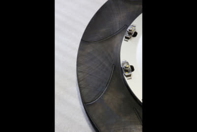 西岡可鍛工業と共同開発したロータ ー。鎌状のシックルスリットは、周速が速く摩擦材表面の炭化が発生しやすい外周側に効率的なスリット効果を生む